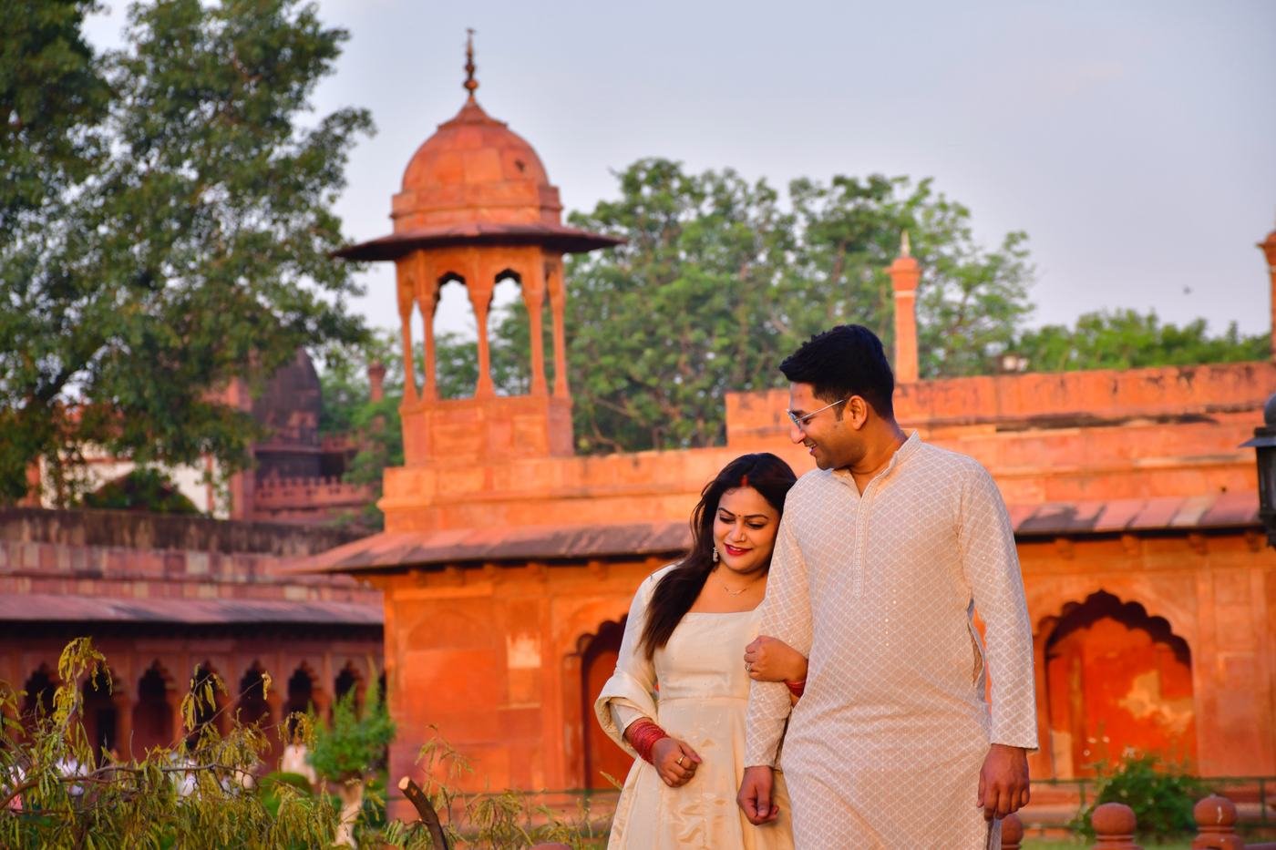 A couple walking through the red sandstone courtyards of Agra Fort